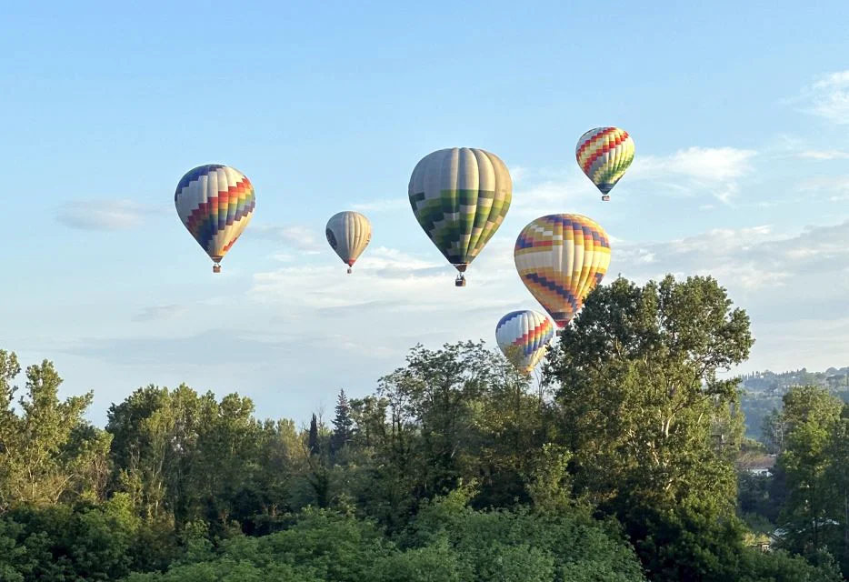 balloons above tuscany landscape
