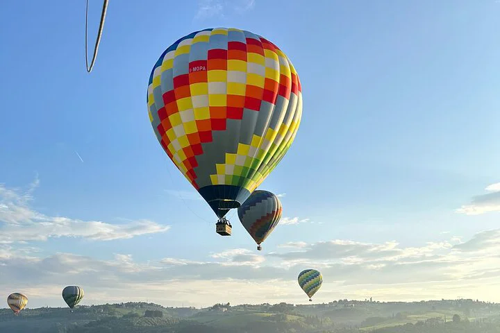 hot air balloons over tuscany hills with rainbow colors