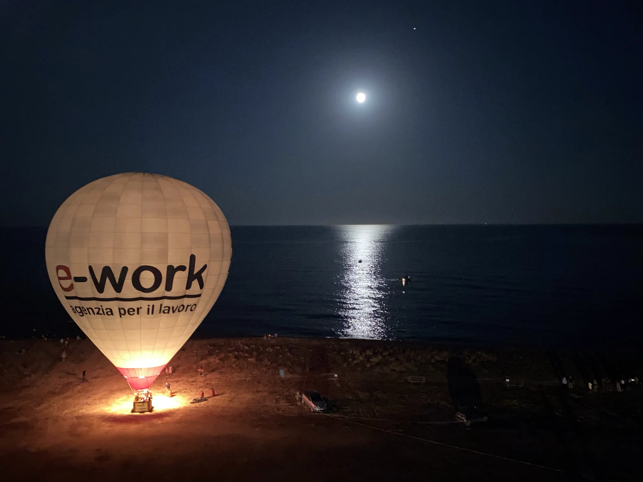 e-work branded hot air balloon on the beach at night