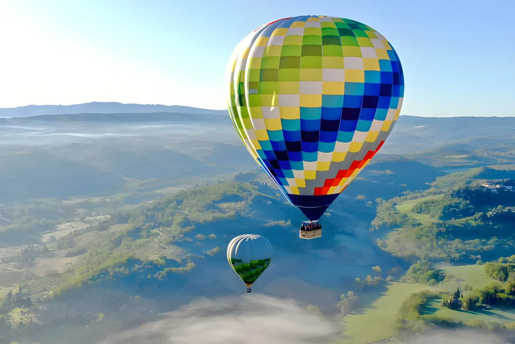 hot air balloons floating above mist in the morning
