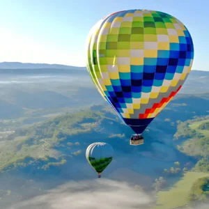 hot air balloons floating above mist in the morning